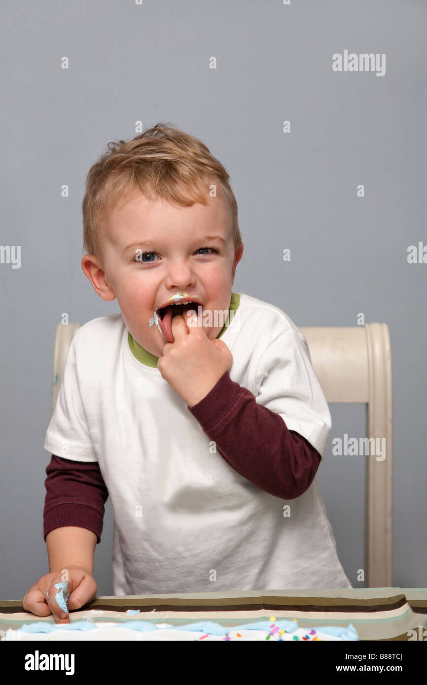 Impish Little Boy Toddler Sneaking Birthday Cake Stock Photo