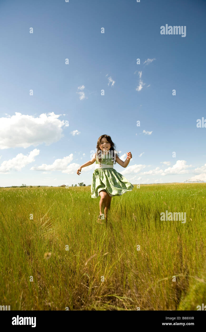 Girl running through a grassy field in North Dakota Stock Photo