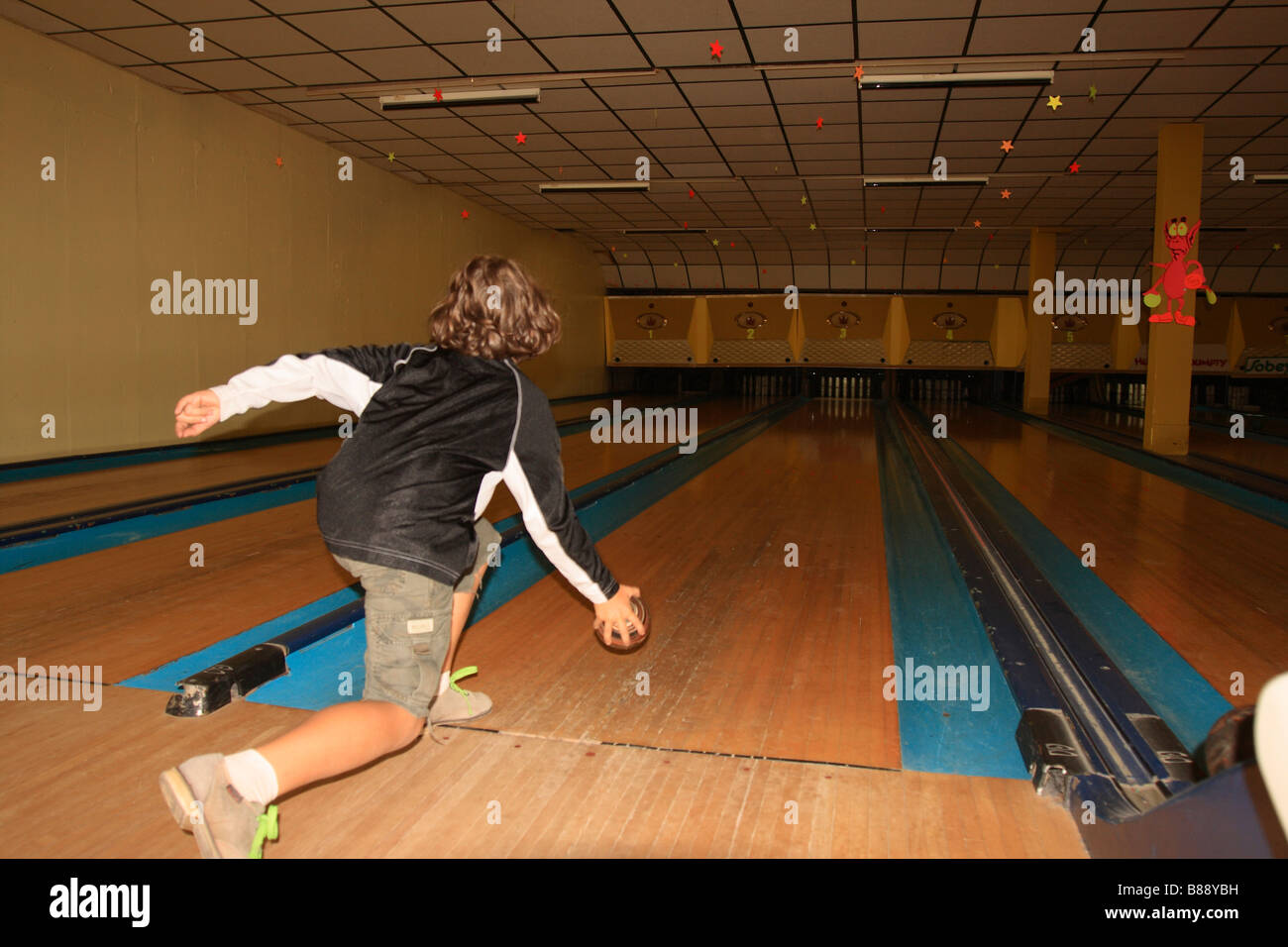 a 7 year old girl bowling at a bowling alley Stock Photo