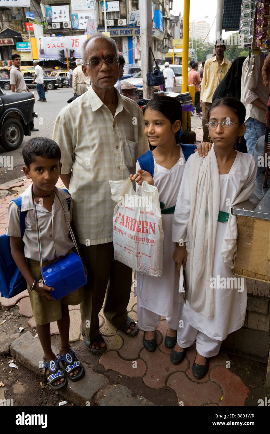 Indian Hindu man with three school children. Mumbai, India. Stock Photo