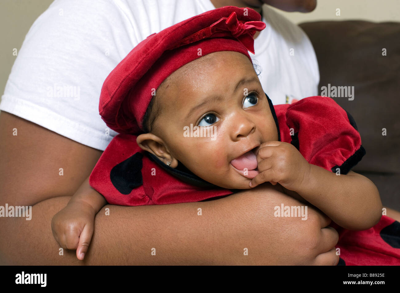 Infant African American girl held in mother's arms Stock Photo