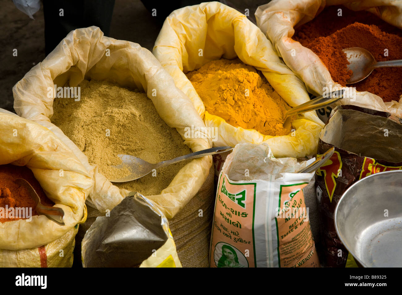 Spices for sale at a street market spice stall, with street seller. Hazira, Surat, Gujarat. India. Stock Photo