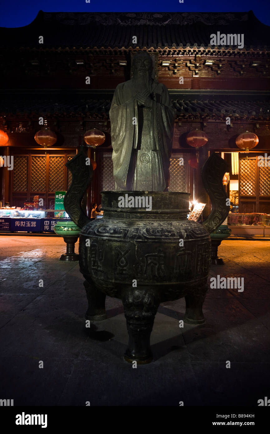 Statue and joss stick burner bowl at the entrance of the Confucius temple in Nanjing at night. Stock Photo