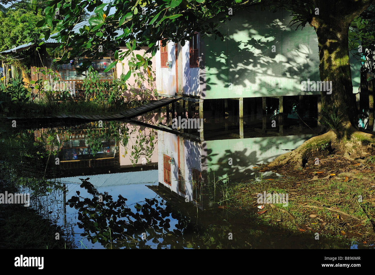 Reflections of a house in tropical flood water Stock Photo