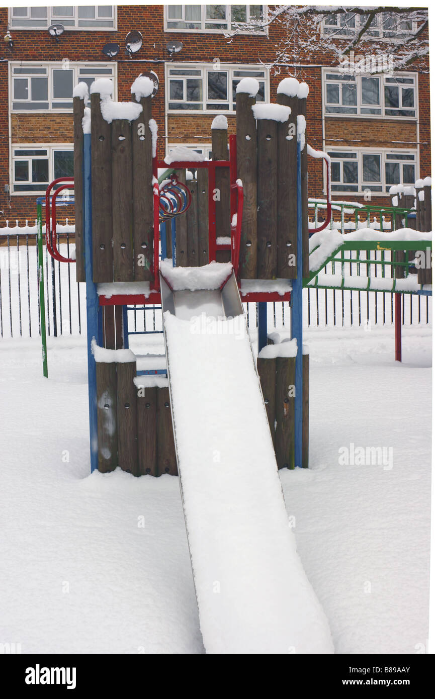 North London estate playground / playground slide covered in untouched snow after heaviest snowfall in years. Stock Photo