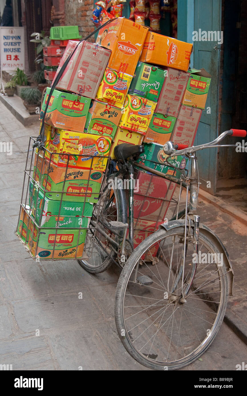 Asian lifestyle with reportage image of an overloaded bicycle full of boxes and cartons, an Asian delivery service on the backstreets of Kathmandu Stock Photo