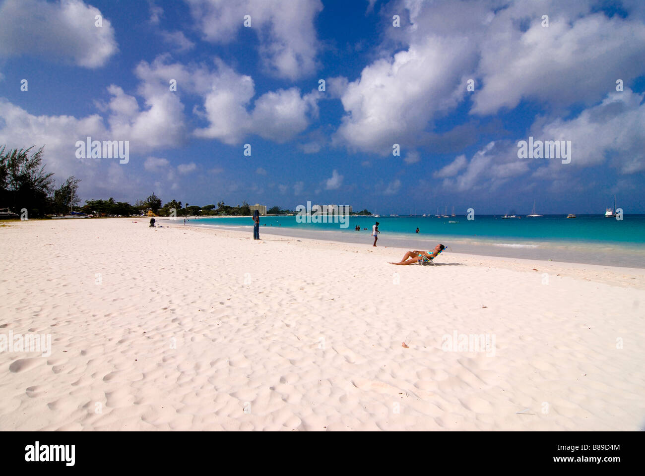A few people enjoying the sun at the Carlisle Bay beach of Barabados Caribbean Stock Photo