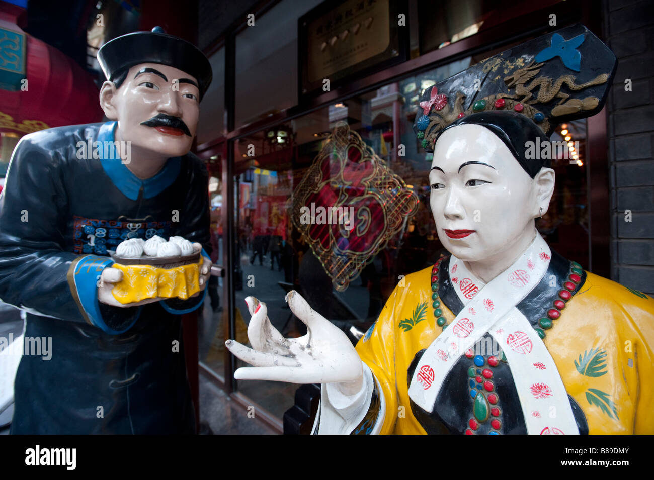 Life size statues of waiter and customer in traditional costume outside dumpling restaurant in Qianmen central Beijing 2009 Stock Photo