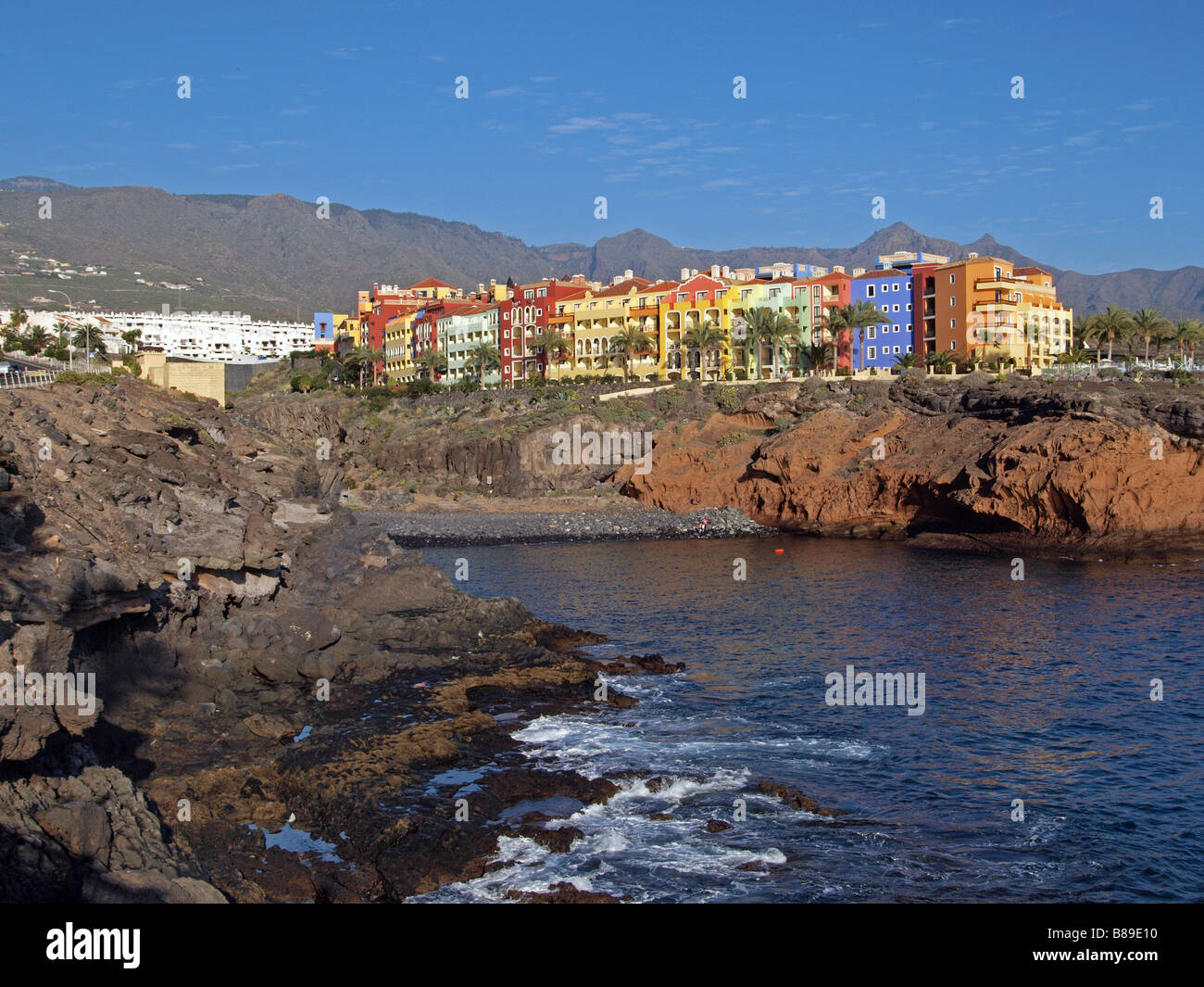 Colourful houses in the cliff top, with beach in the forground at Playa Parasio, Costa Adeje, Tenerife. Stock Photo