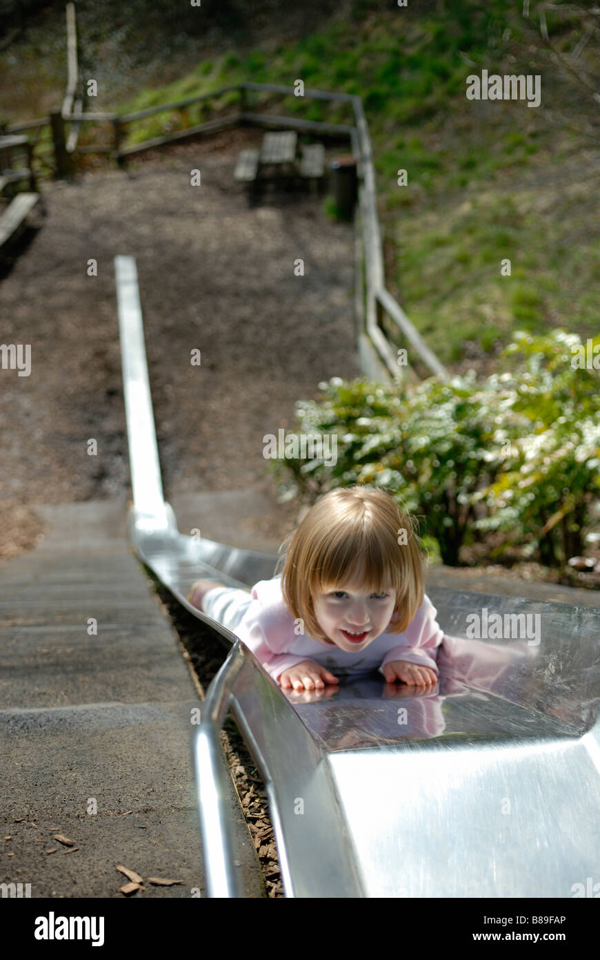 Young girl on slide in playground Stock Photo - Alamy