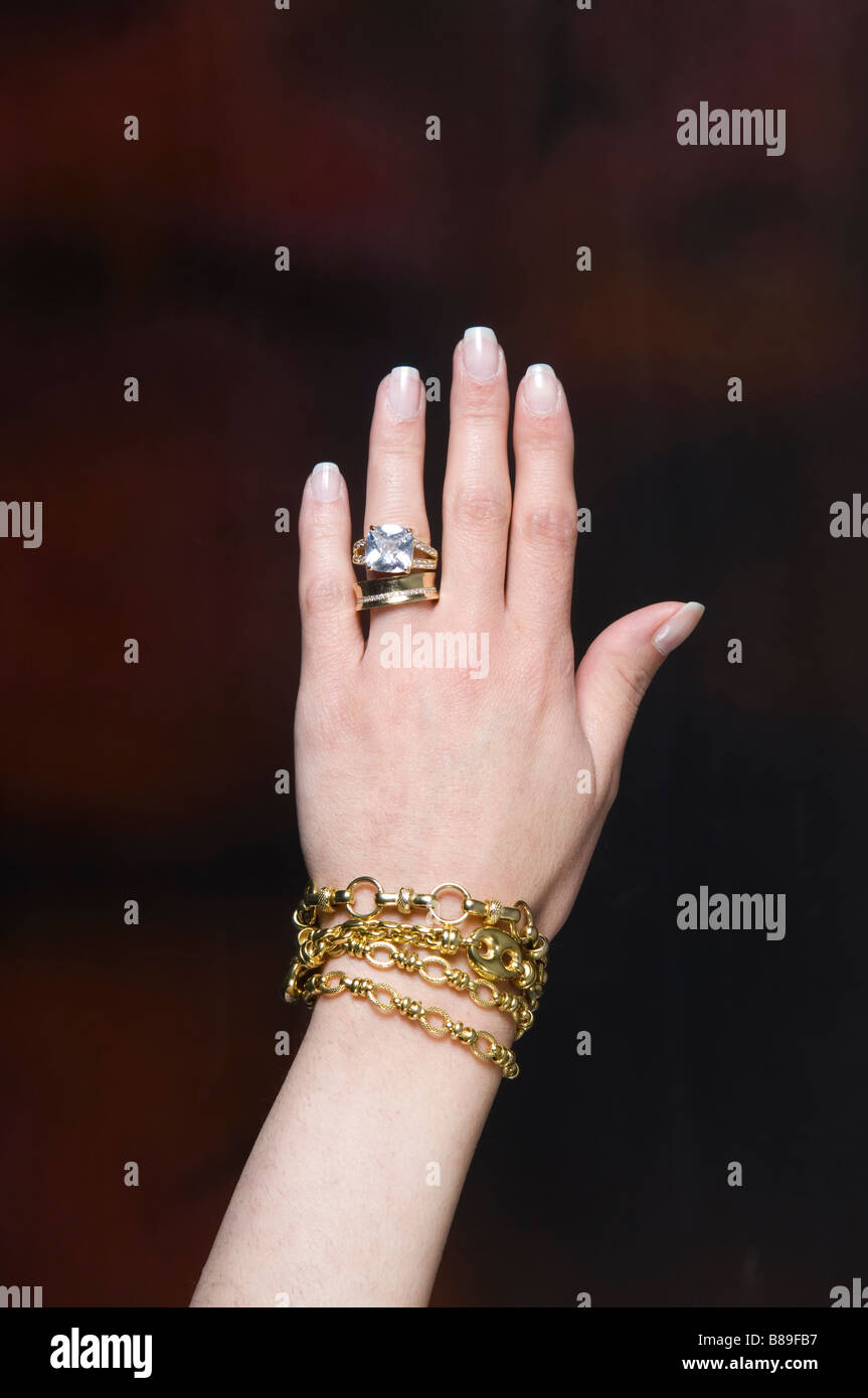 Woman wearing a big diamond ring and golden bracelets Stock Photo