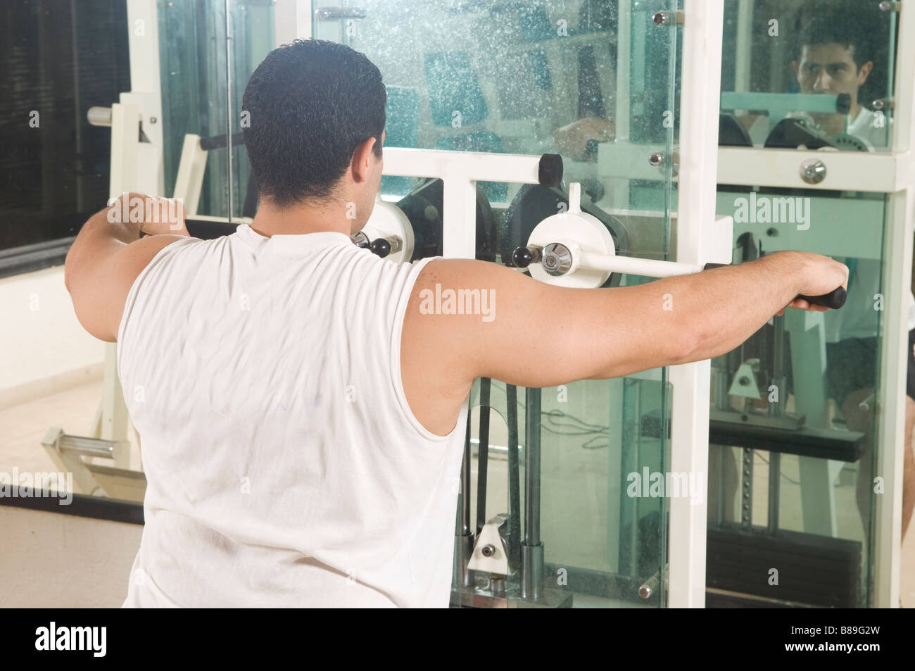 Man in the gym using front deltoid machine Stock Photo