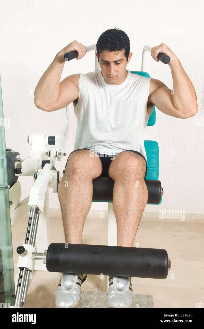 Man doing abdominal crunches on machine in the gym Stock Photo
