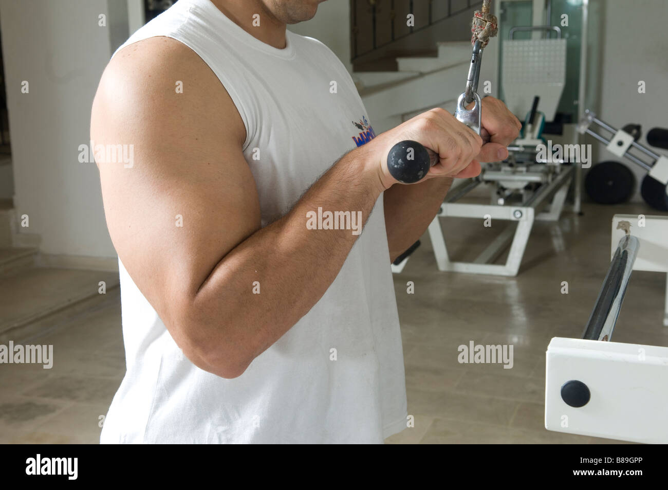 Man doing triceps cable pull down exercise in the gym Stock Photo
