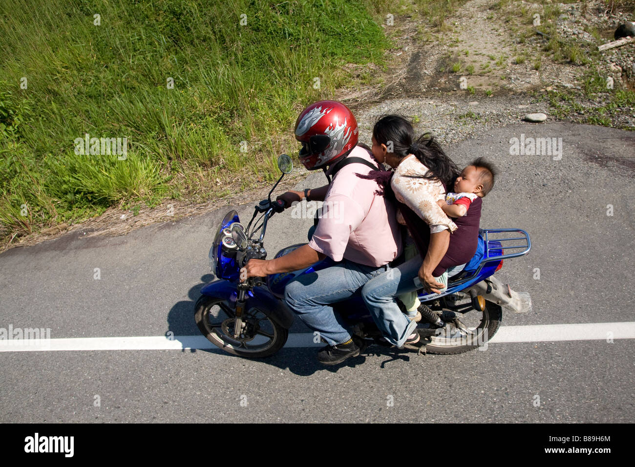 four 4 people family on a moped motorbike Ecuador South America  71023 Ecuador Stock Photo