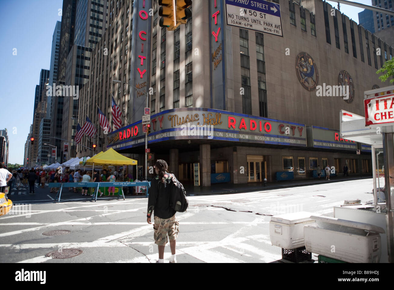 Man standing on the intersection of 6th Ave with W 50th Street in front