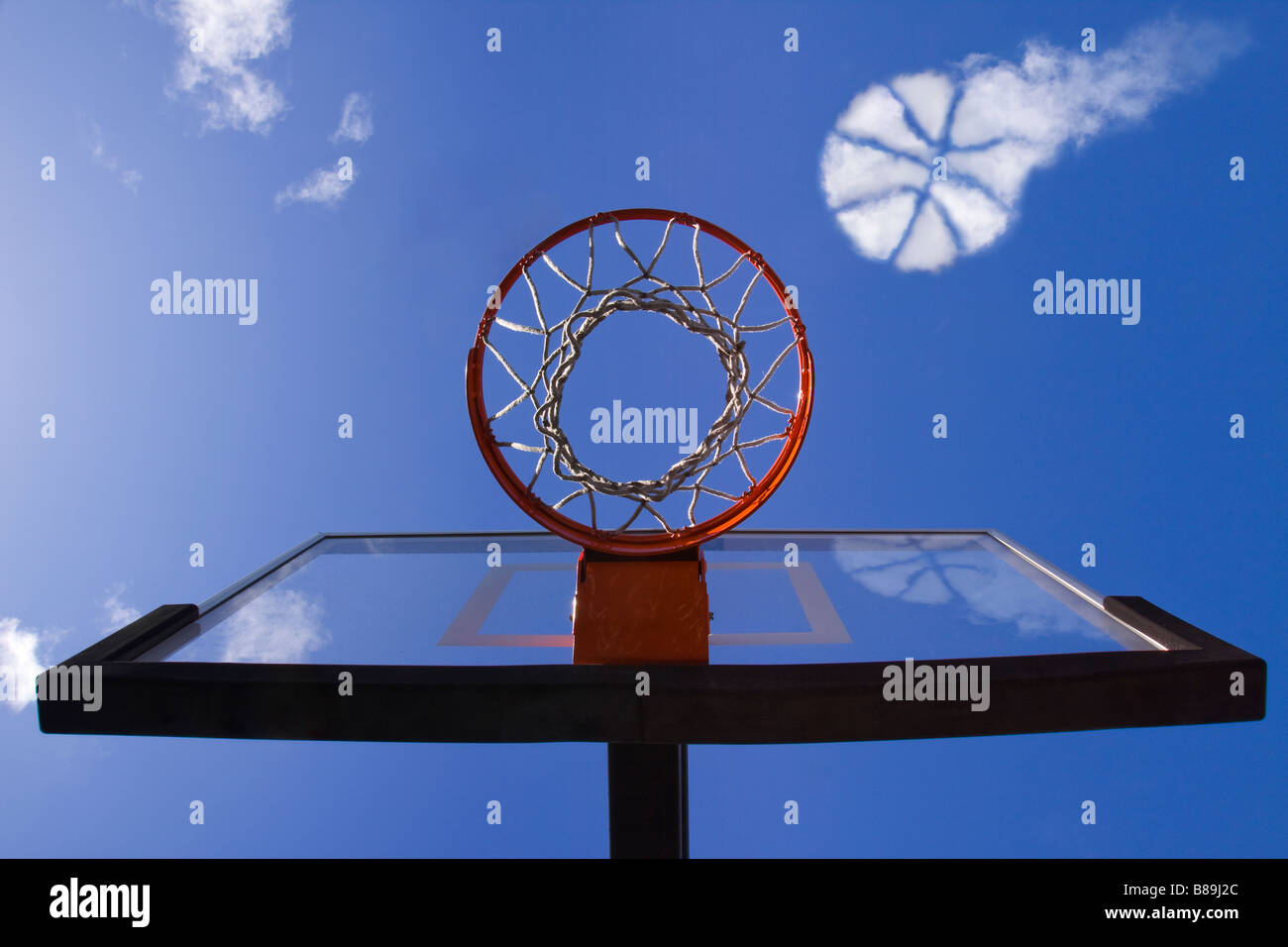 Cloud in the sky in the shape of a basketball approaching a basketball hoop as if it is about to go into the net Stock Photo