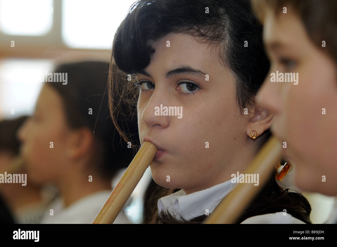 A student playing the flute during a music class at her primary school