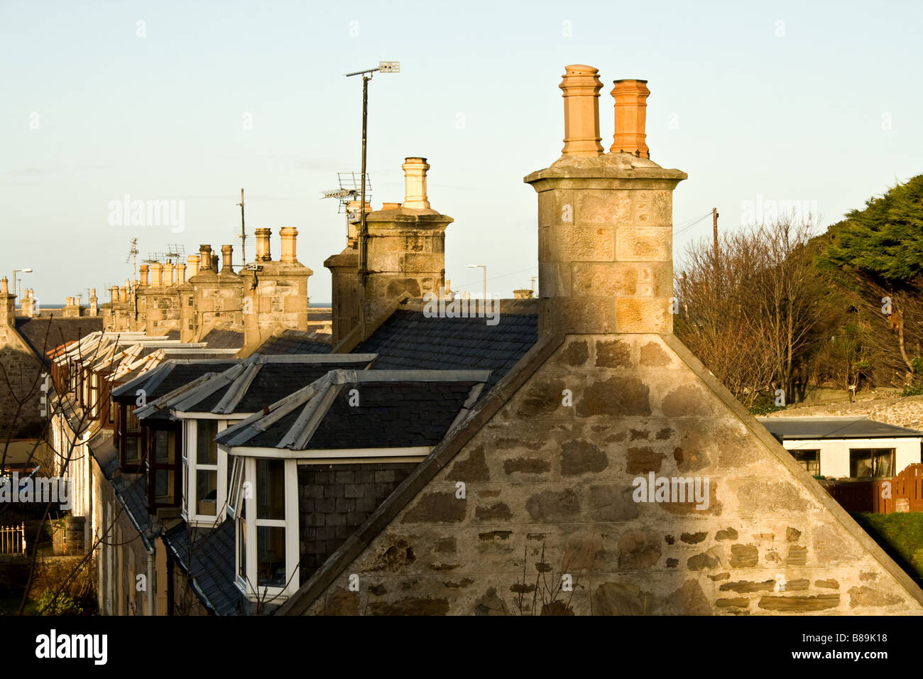 Row of Stone houses with chimneys and white framed windows in Buckie, Scotland Stock Photo