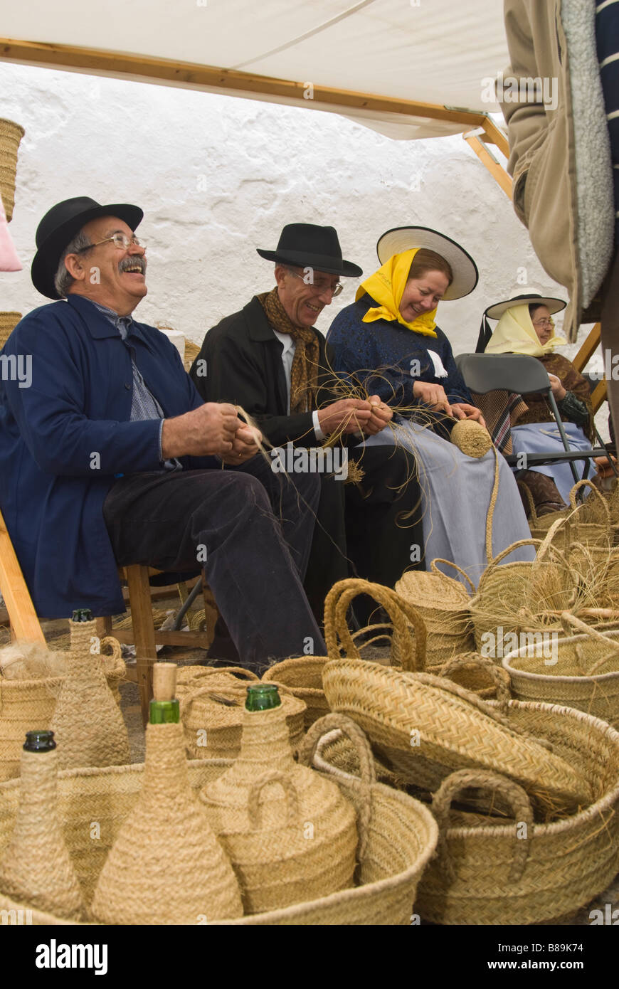 Craftsmen in traditional costume making baskets out of esparto at the Traditional Handicrafts Fair, Santa Eulalia, Ibiza, Spain Stock Photo