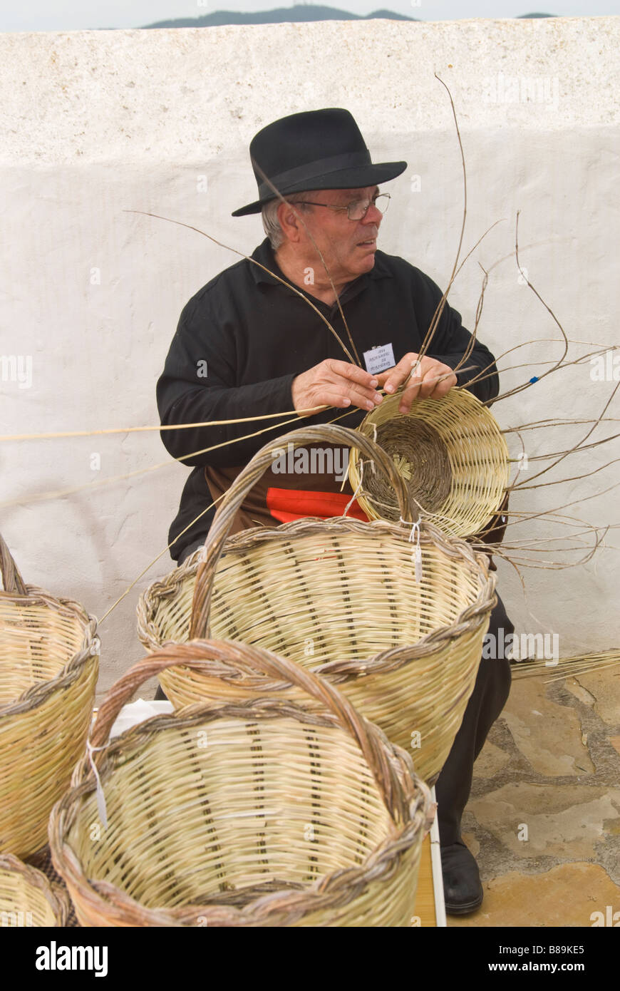 Craftsman in traditional costume making baskets out of wicker at the Traditional Handicrafts Fair, Santa Eulalia, Ibiza, Spain Stock Photo