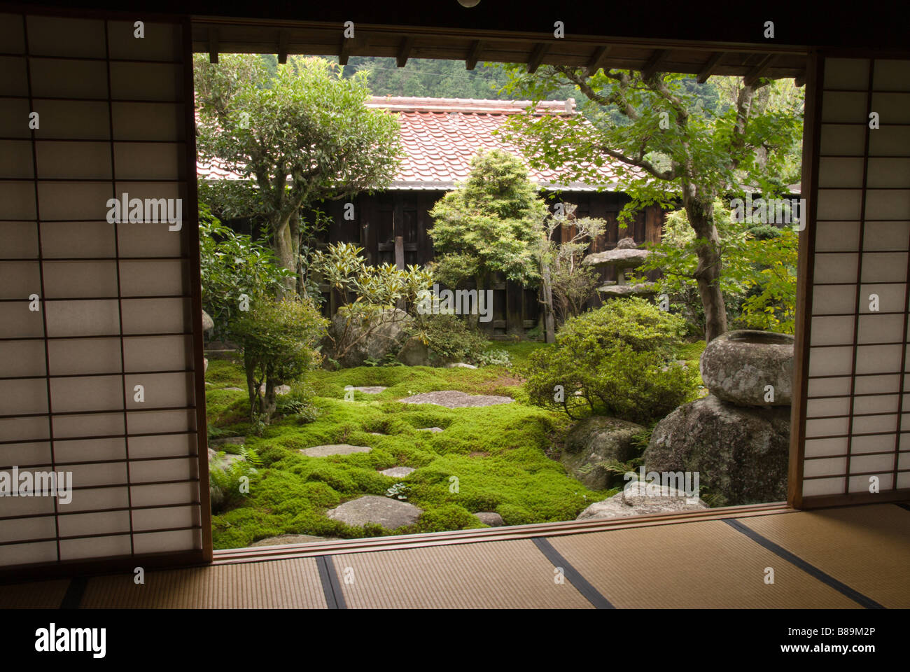Shoji paper screens open on to a traditional Japanese garden at the Wakihonjjin, Tsumago Stock Photo