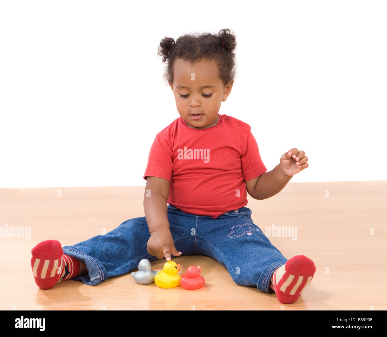 Beautiful african girl playing with three ducks of plastic Stock Photo
