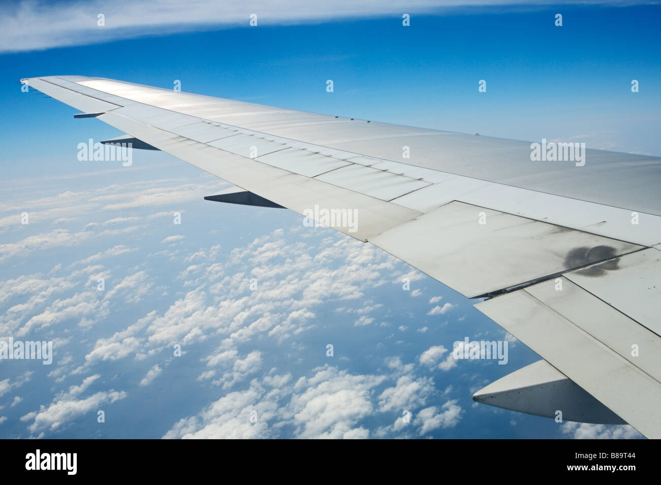 Airplane wing in the blue sky with white clouds Stock Photo - Alamy