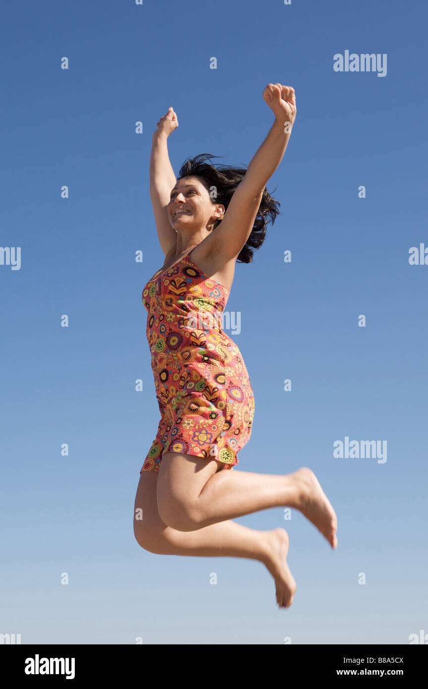 Beautiful girl jumping a over sky background Stock Photo - Alamy