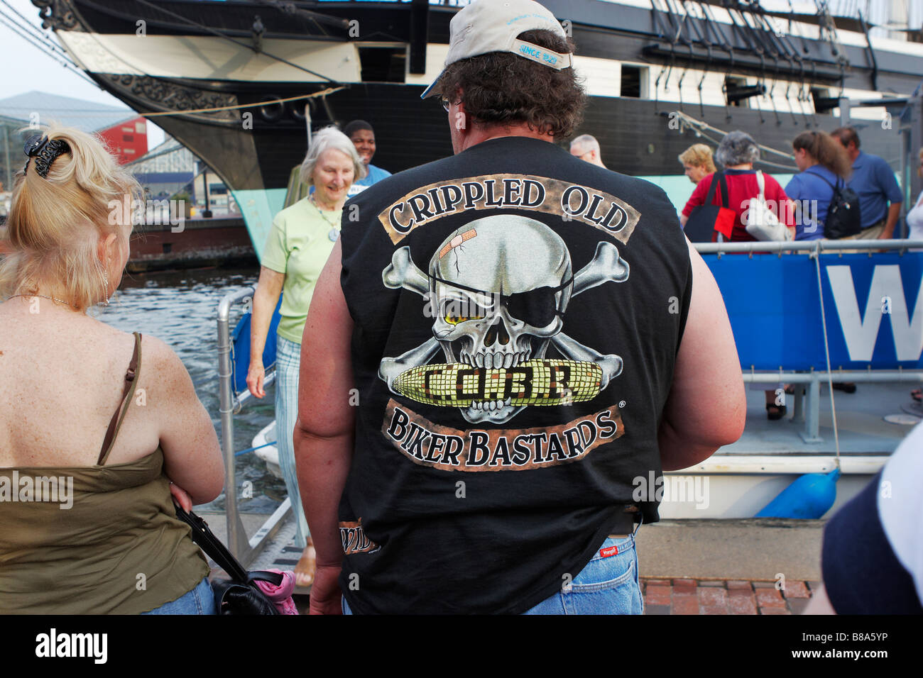 An aging biker among tourists at the Inner Harbor Baltimore Stock Photo