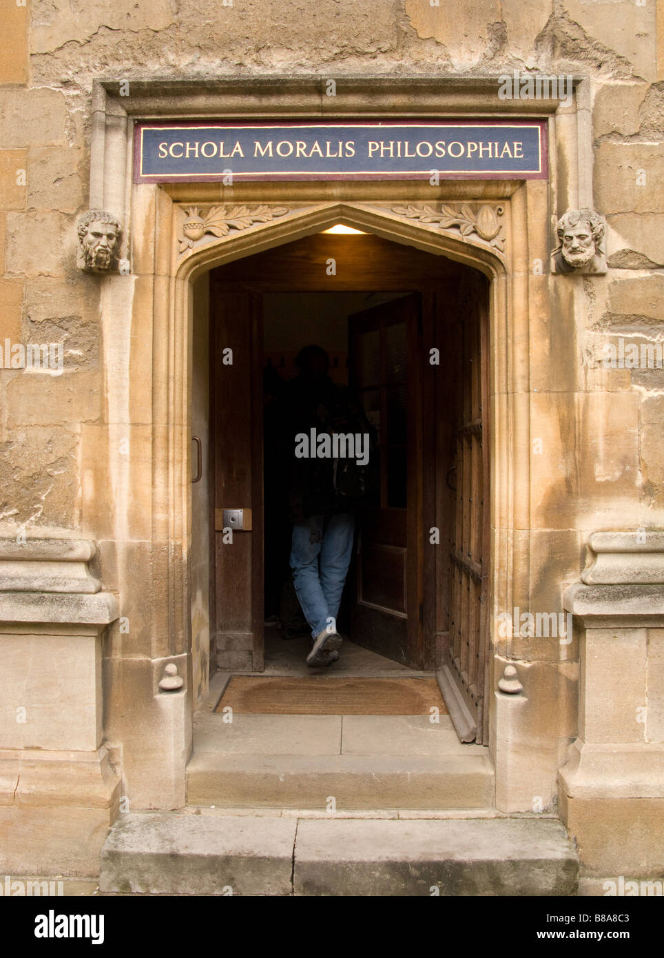 Person walking through door to the School of Moral Philosophy (or Schola Moralis Philosophiae), Bodleian Library, Oxford, UK Stock Photo