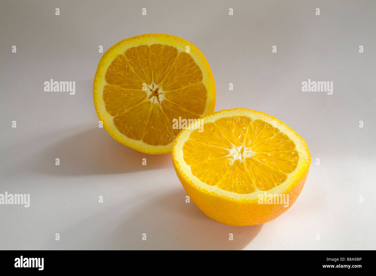 STILL LIFE FRUIT VEGETABLE Two halves of a navel orange sliced evenly Stock Photo