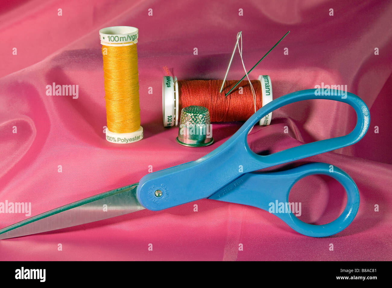 A sewing kit containing needles thread on spools scissors and thimble Stock Photo