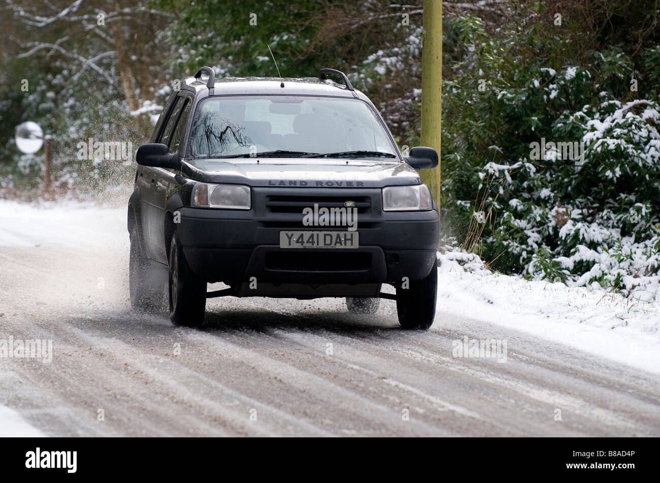 Land rover driving down a snowy country road Stock Photo