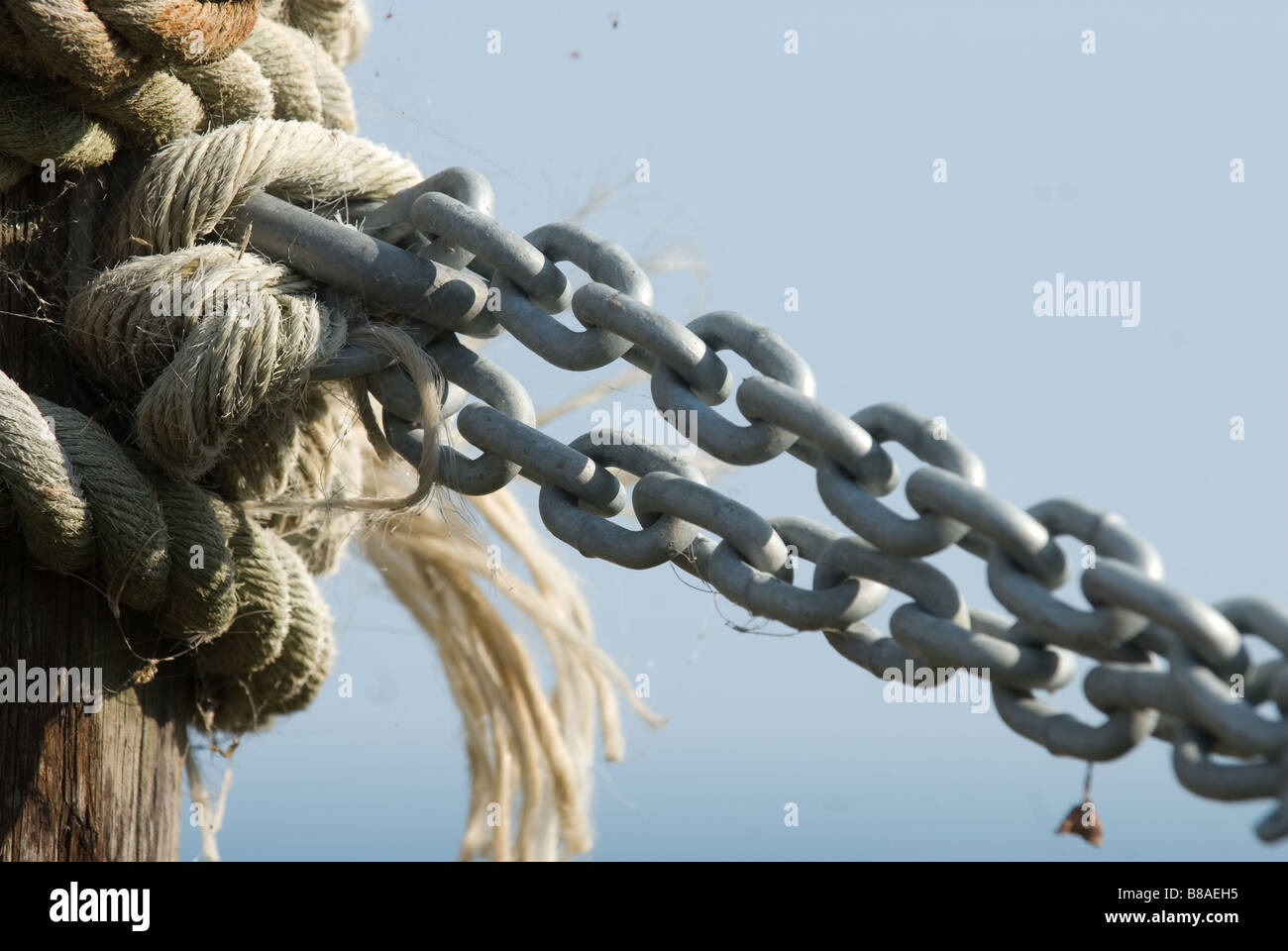 Chain and rope attached to wooden post Stock Photo - Alamy