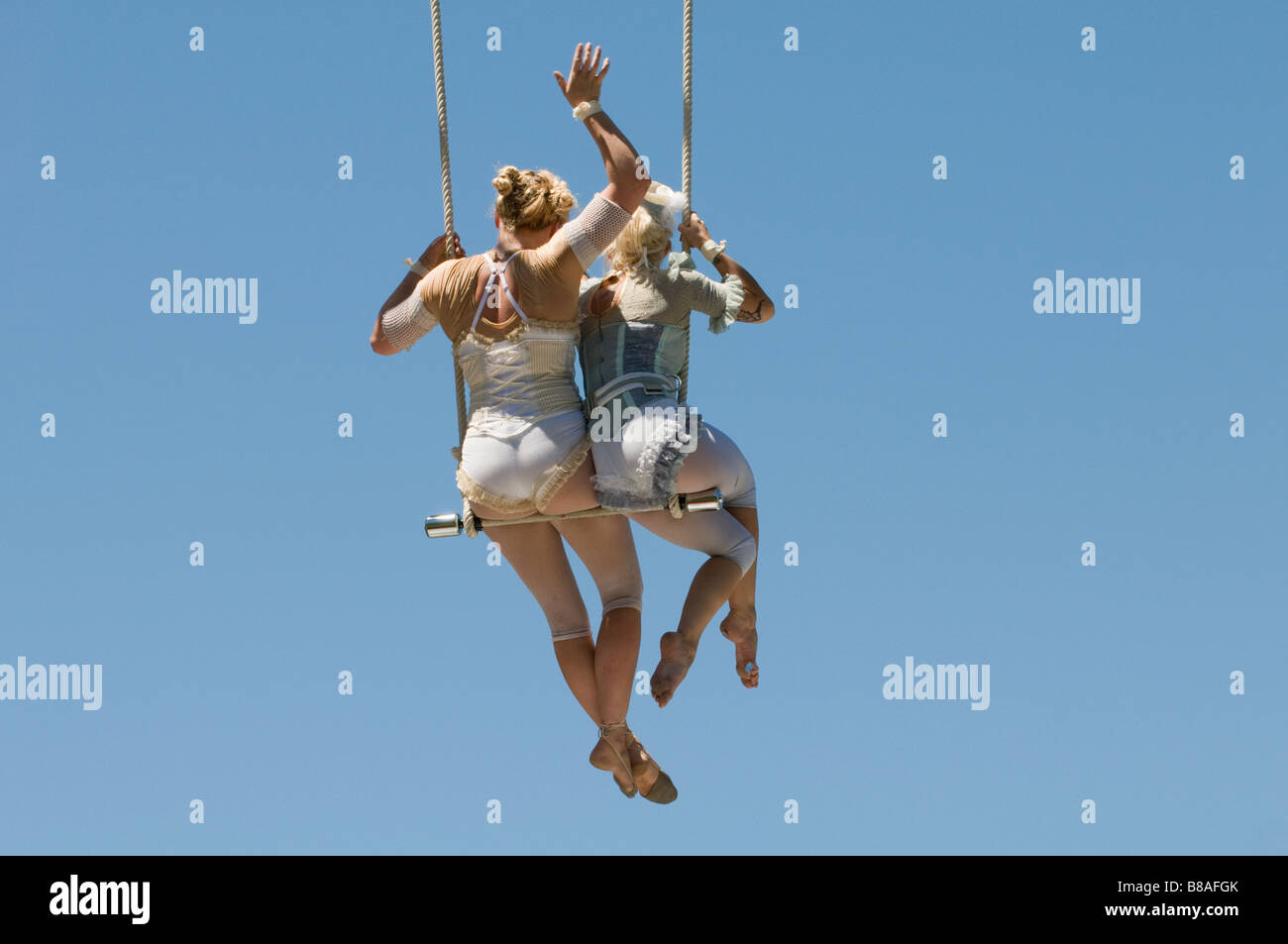 Two female trapeze artists on swing Stock Photo