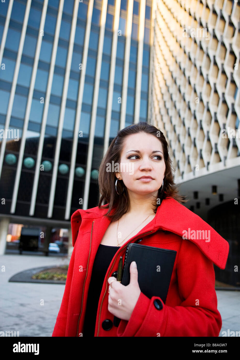 Caucasian female standing in front of office building Stock Photo