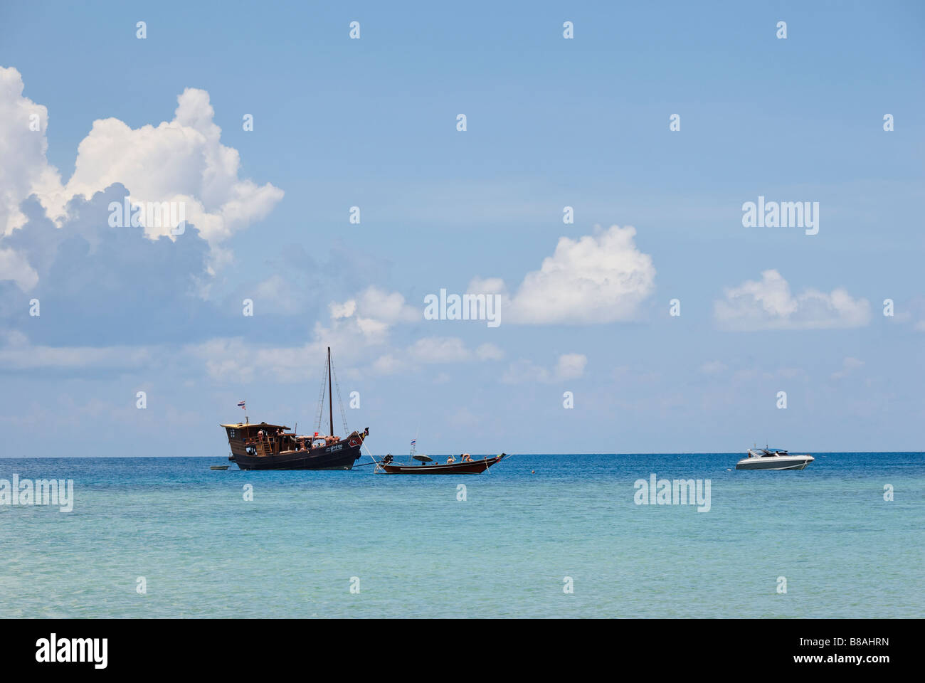 Diving boats anchored offshore from the island of Koh Pangan Thailand Stock Photo