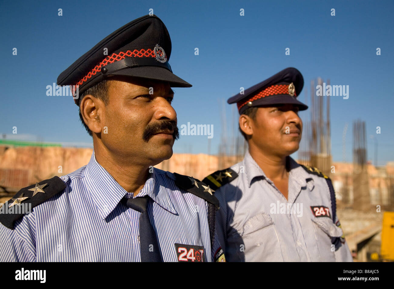 Two uniformed security guards work on a construction site in Bangalore