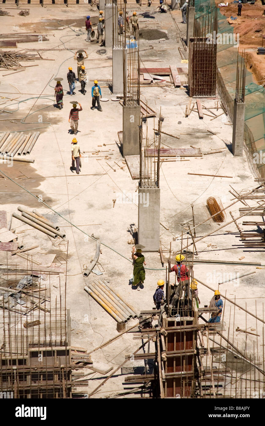 Men and women work together to pour concrete on the steel rod ...