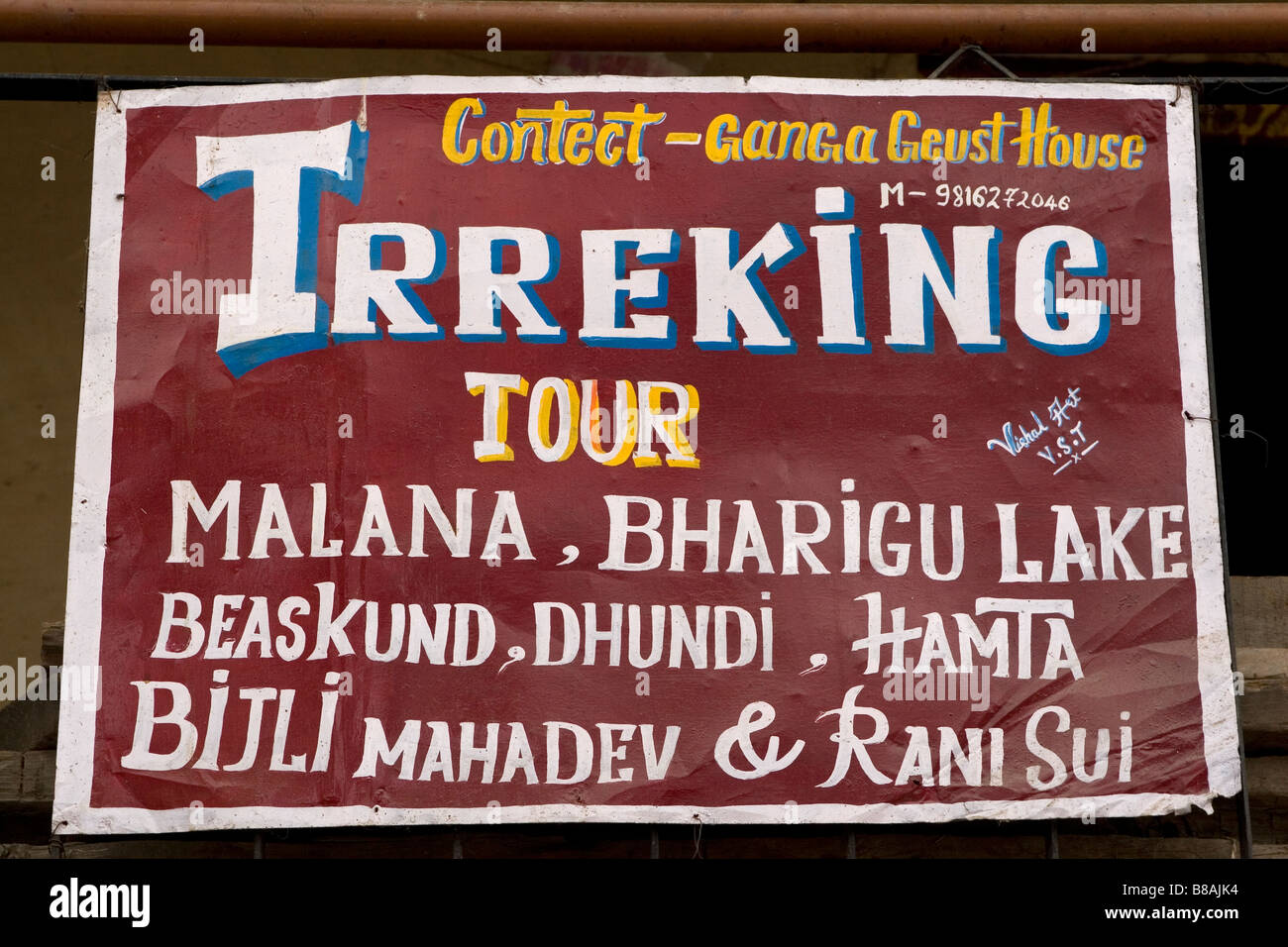 A sign offers a trekking tour in Manali in northern India. The hand painted sign is badly spelled. Stock Photo