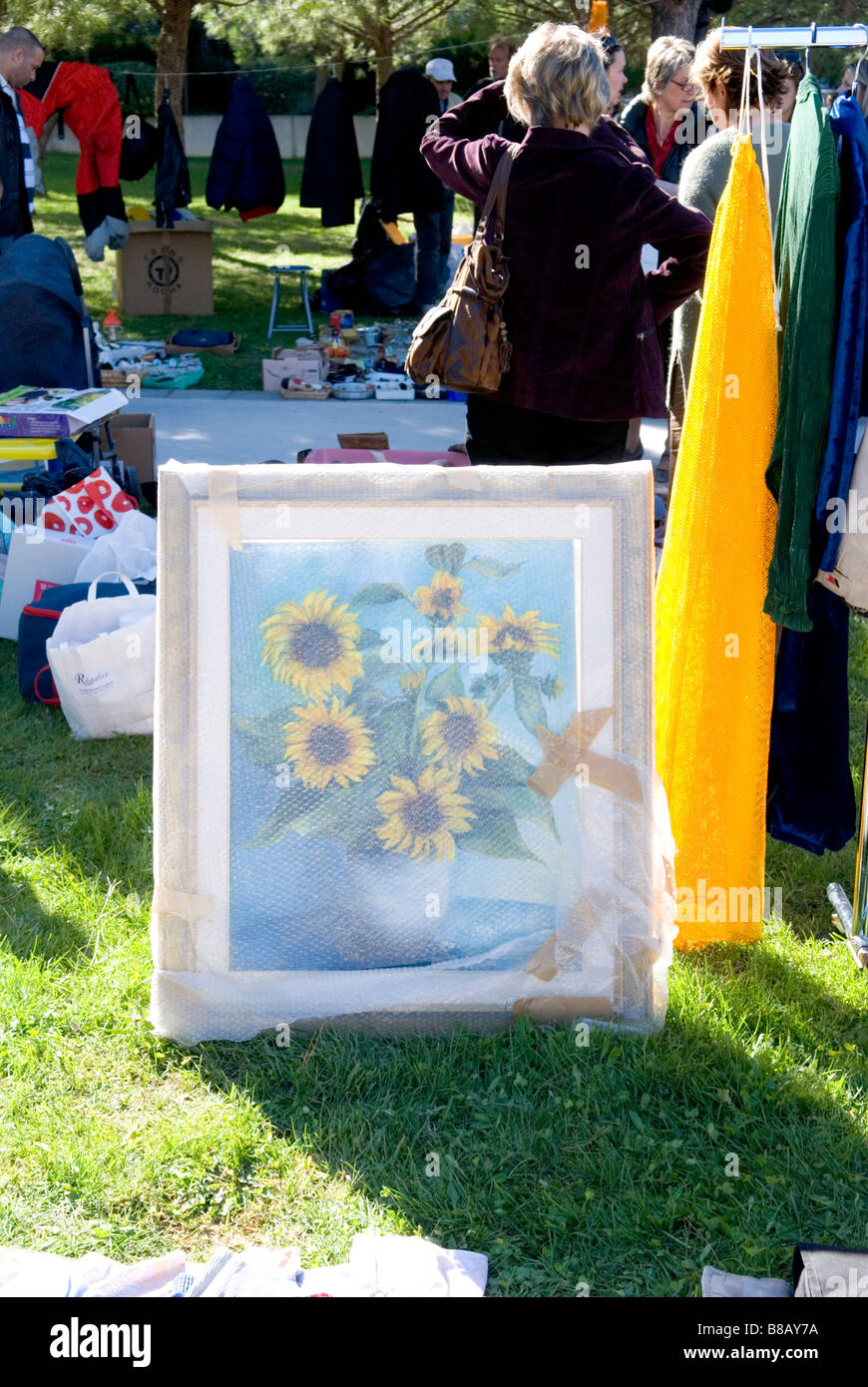 a kitsch painting of vase of sunflowers wrapped in bubble wrap on sale at car-boot sale in park Stock Photo