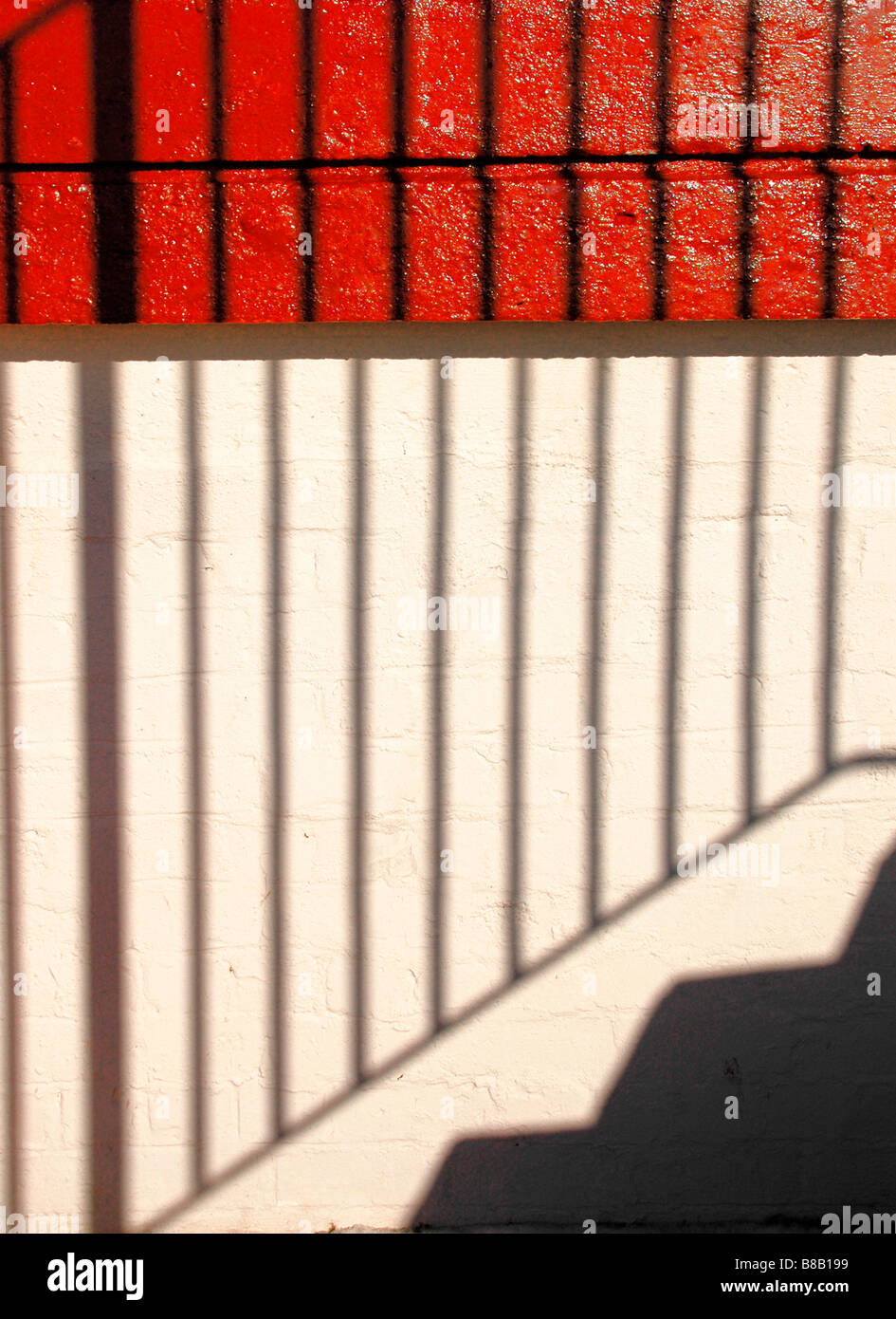 Shadow of steps and railings against a building wall. Stock Photo