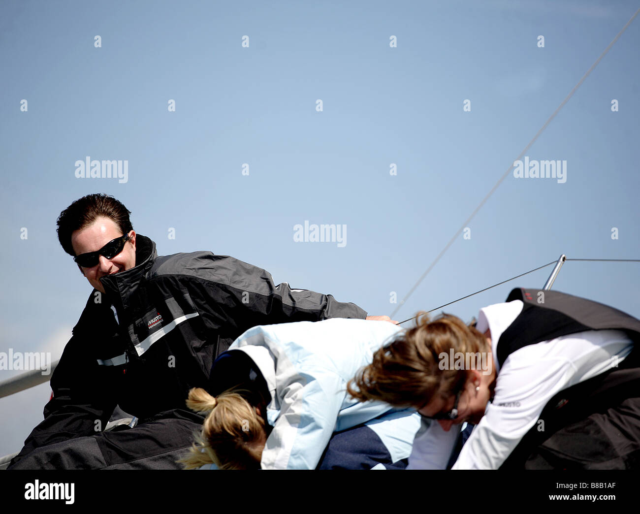 3 people 1 male 2 female having fun on a sailing yacht. Stock Photo
