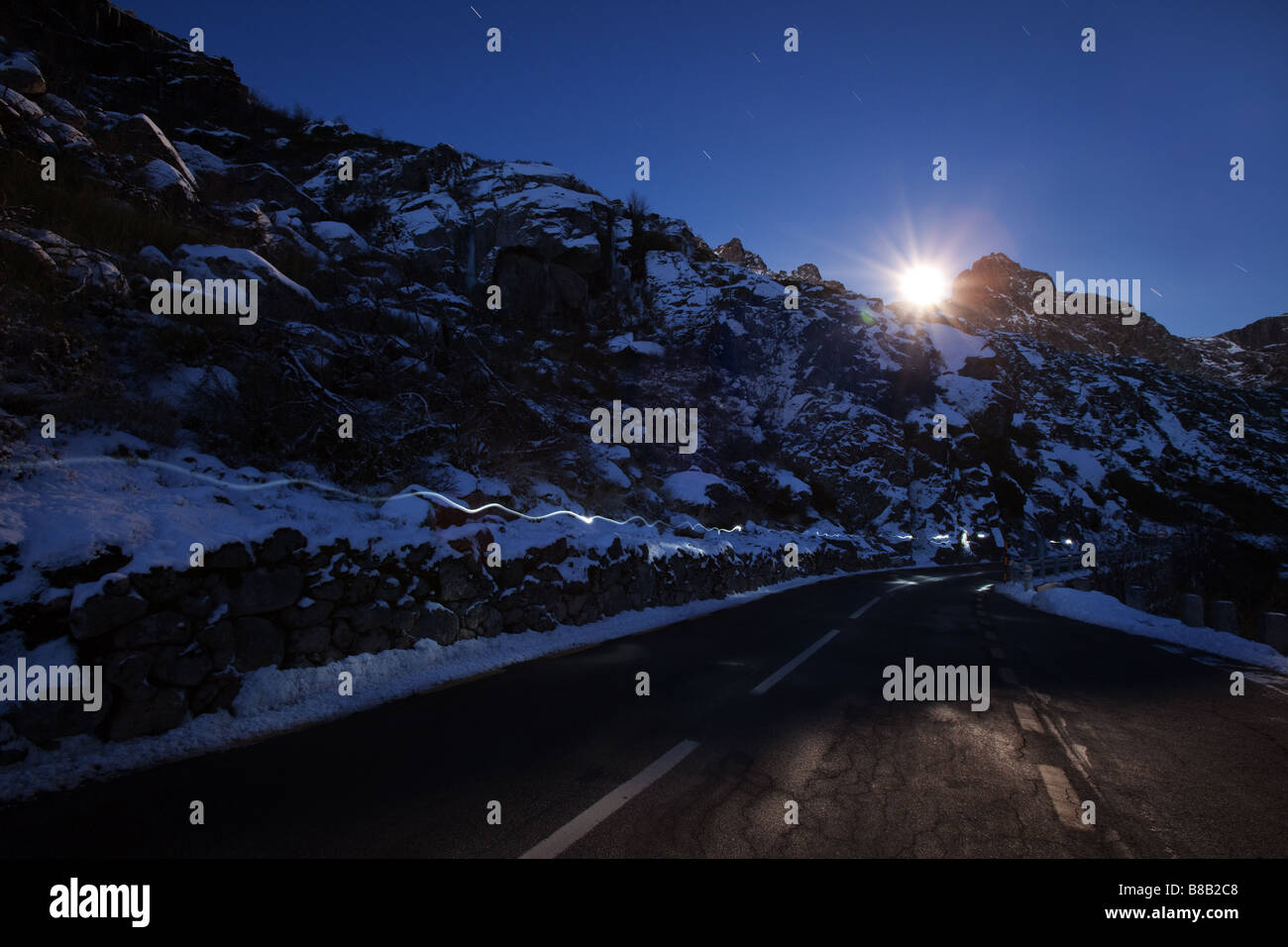 Moonset over Cantaro Magro at winter with stars snow and road on the foreground Stock Photo