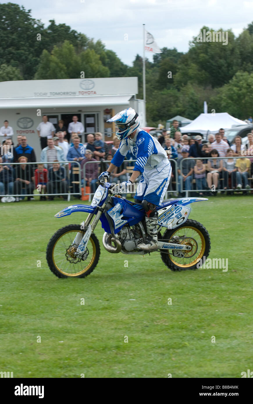 off road motorbike ridden by stuntman in front of crowd at autoshow