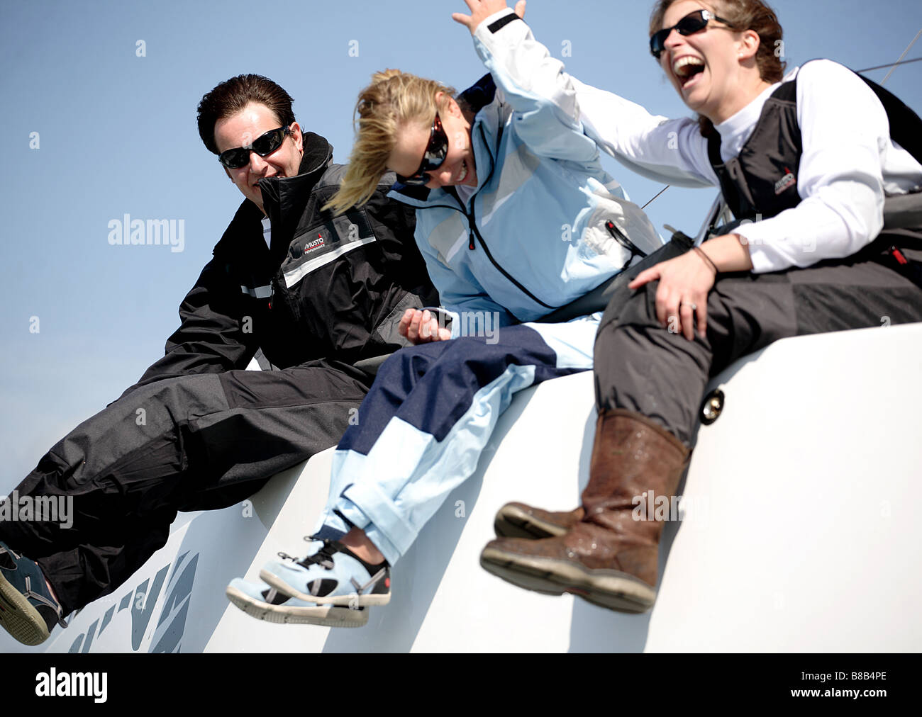 3 sailors, 2 woman, one man having fun on a yacht. Stock Photo