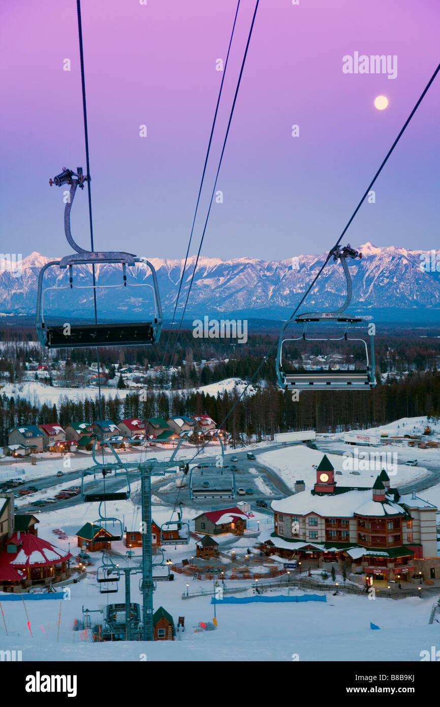 Early evening at Kimberley Alpine Resort from the top of main piste towards village witn moon in sky over Canadian Rockies Stock Photo