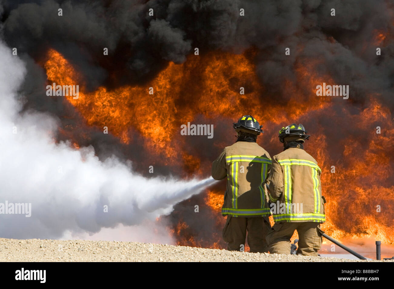 Firefighters using fire retardant foam to put out a jet fuel fire at an airport training facility in Boise Idaho USA Stock Photo