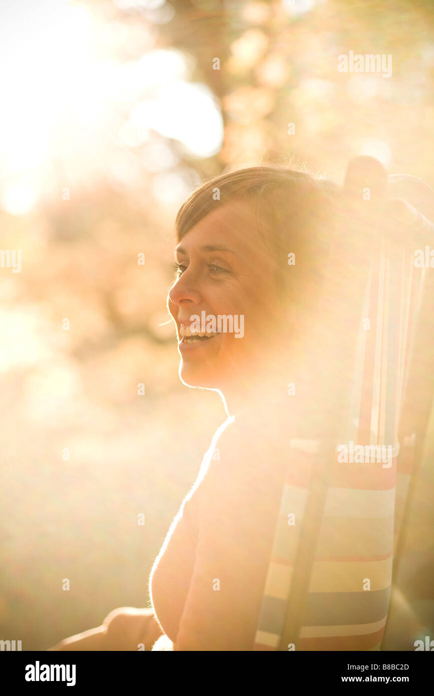 Woman smiling while relaxing outdoors Stock Photo - Alamy